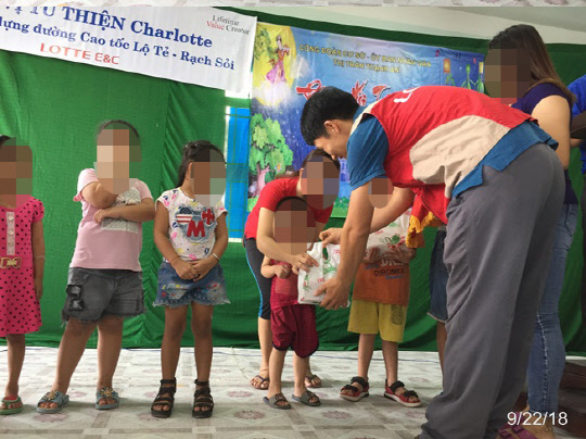 베트남  로테-락소이 고속도로 1공구 현장에서 샤롯데봉사단이 주민들에게 명절선물을 전하고 있다. <롯데건설 제공>